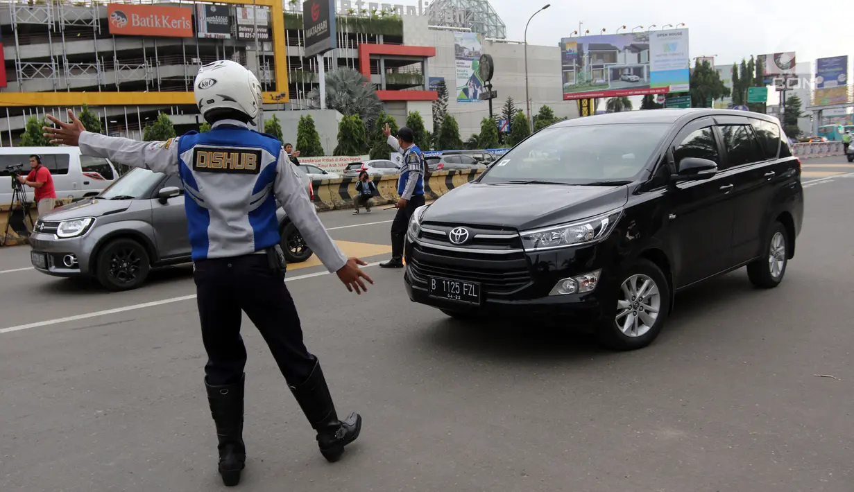 Petugas Dishub memberi arahan kepada pengendara mobil di depan Gerbang Tol Bekasi Barat 1, Bekasi, Jawa Barat, Senin (12/3). Penerapan ganjil-genap hanya berlaku di gerbang tol Bekasi Barat dan Timur. (Liputan6.com/Arya Manggala)