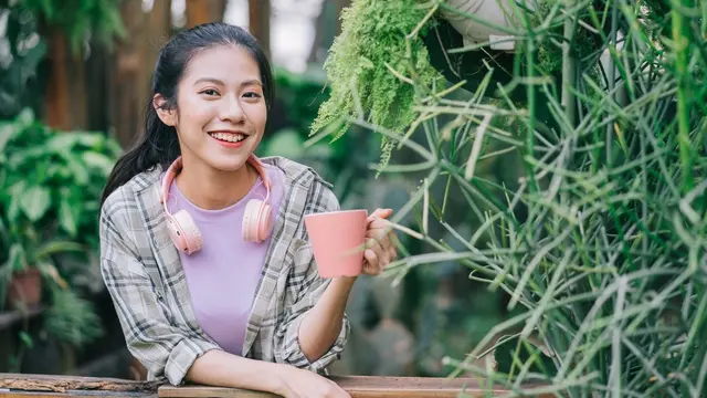 perempuan santai minum teh di taman