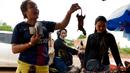 Seorang wanita saat membeli tikus bakar di sebuah kios di provinsi Battambang, Kamboja (8/8/2019). Tikus bakar yang tusuk sate harganya masing-masing 0,25 USD atau sekitar 3500 rupiah. (AFP Photo/Tang Chhin Sotthy)