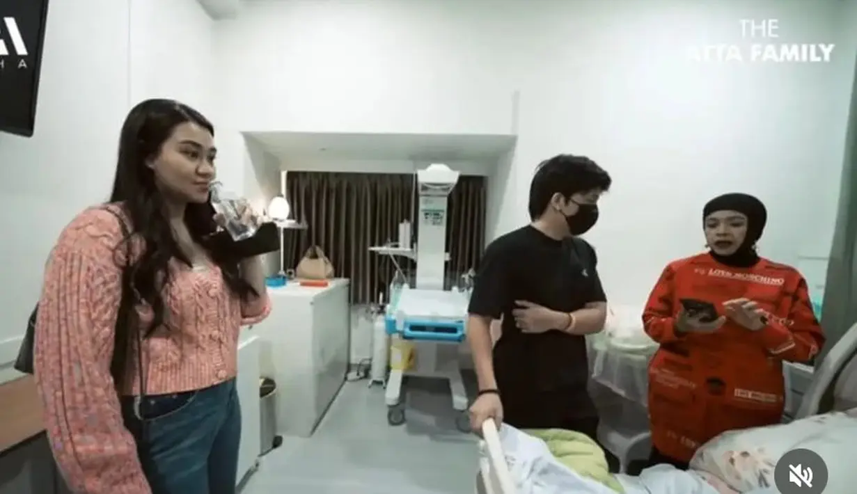 Saat menemani persalinan Aurel, Aaliyah mengenakan jaket ceop top knit pink dipadukan celana denimnya. [YouTube The Atta Family]