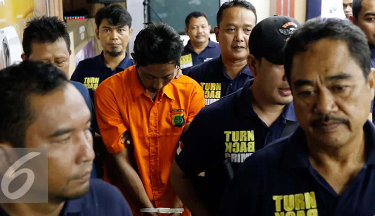 Petugas membawa HK tersangka pembunuhan ibu dan anak di Penggilingan, Cakung, Jakarta Timur dihadirkan saat rilis pengungkapan kasus di Mapolda Metro Jaya, Jakarta, Jumat (16/10/2015). (Liputan6.com/Yoppy Renato)