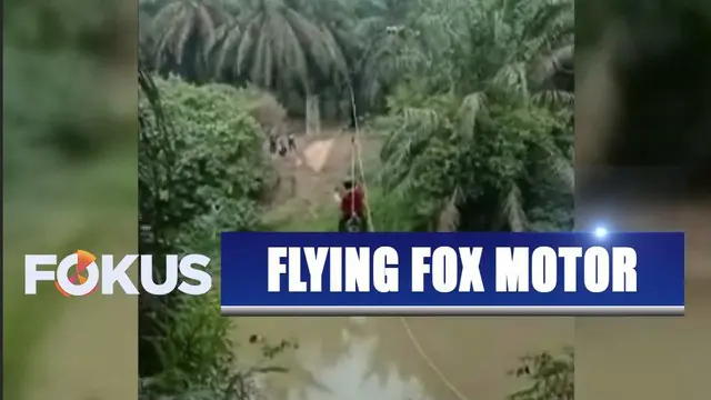 Dua orang wanita muda menyebrangi sungai menggunakan sepeda motor yang tergantung tali layaknya flying fox.