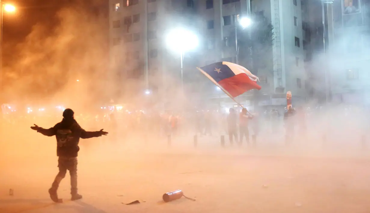 Suporter Chili mengibarkan bendera nasional Chili merayakan kemenangan Chili atas Peru di Copa Amerika 2015  di sepanjang jalan kota Santiago, (29/6/2015). Chile melaju ke final usai mengalahkan Peru 2-1. (REUTERS/Pablo Sanhueza)