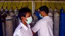 Petugas medis membawa tangki oksigen di sebuah rumah sakit di Lhokseumawe, Aceh, Selasa (7/7/2021). Indonesia memperluas pembatasan untuk memerangi gelombang virus corona COVID-19 yang mematikan. (Azwar Ipank/AFP)