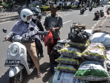 Pedagang arang melayani pembeli di kawasan Manggarai, Jakarta Selatan, Minggu (10/7/2022). Perayaan Idul Adha membawa berkah tersendiri bagi para pedagang arang musiman di kawasan Manggarai karena banya warga membeli untuk tradisi membakar sate. (merdeka.com/Iqbal S. Nugroho)