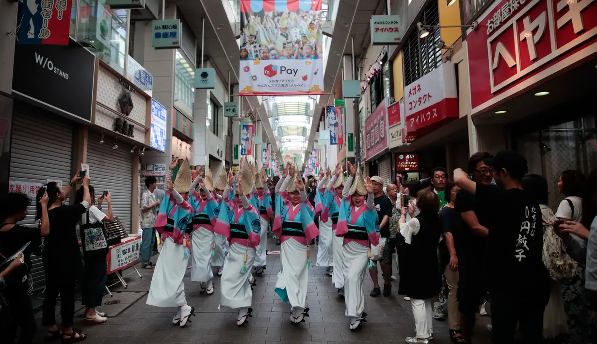 Penari mengenakan topi jerami tampil sebelum dimulainya festival tari Koenji Awa-Odori di kawasan Koenji, Tokyo pada 24 Agustus 2019. Dimulai pada 1950-an, Koenji Awa Odori telah berkembang menjadi salah satu festival musim panas terbesar dan terpopuler di Tokyo. (AP/Jae C. Hong)