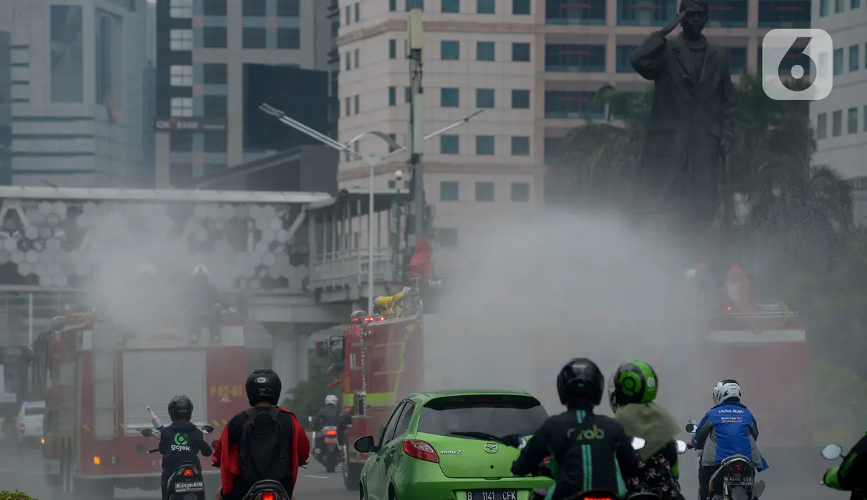 Petugas pemadam kebakaran (Damkar) melakukan penyemprotan cairan disinfektan di sepanjang jalan Thamrin-Sudirman, Jakarta, Sabtu (28/3/2020). Penyemprotan menggunakan mobil pemadam kebakaran tersebut bertujuan untuk mengantisipasi penyebaran Virus Corona (COVID-19). (merdeka.com/Imam Buhori)