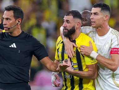 Pemain Al Nassr, Cristiano Ronaldo (kanan) mencoba meredam emosi dari pemain Ittihad FC, Karim Benzema pada laga lanjutan Liga Arab Saudi di King Abdullah Sports City, Jeddah, Arab Saudi, Sabtu (07/12/2024) dini hari WIB. (AFP)