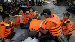 Petugas Basarnas mengevakuasi warga menggunakan perahu karet ketika banjir melanda Perumahan Ciledug Indah 1, Tangerang, Selasa (10/2/2015). Banjir merendam ratusan rumah di kawasan tersebut dengan ketinggian mencapai 90 cm. (Liputan6.com/Andrian M Tunay)