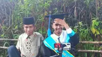 Ahmad Krismon bersama ayahnya saat wisuda online di perbukitan Kabupaten Agam. (Liputan6.com/ dok instagram @bukittinggisorak)