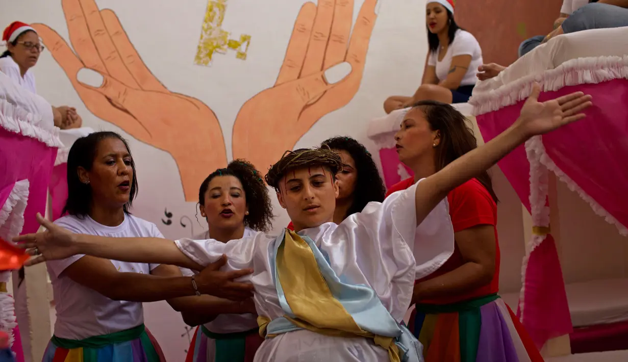 Narapidana perempuan mengenakan kostum dalam acara tahunan menjelang  natal di Penjara Nelson Hungria, Rio de Janeiro, Kamis (13/12). Para tahanan juga menyanyikan lagu religi dan memainkan drama perjalanan hidup Yesus. (AP/Silvia Izquierdo)