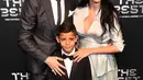 Bintang Real Madrid, Cristiano Ronaldo bersama pasangannya, Georgina Rodriguez dan sang putra, Cristiano Ronaldo Jr berpose setibanya di karpet hijau acara The Best FIFA Football Awards, London, Senin (23/10). (Glyn KIRK/AFP)