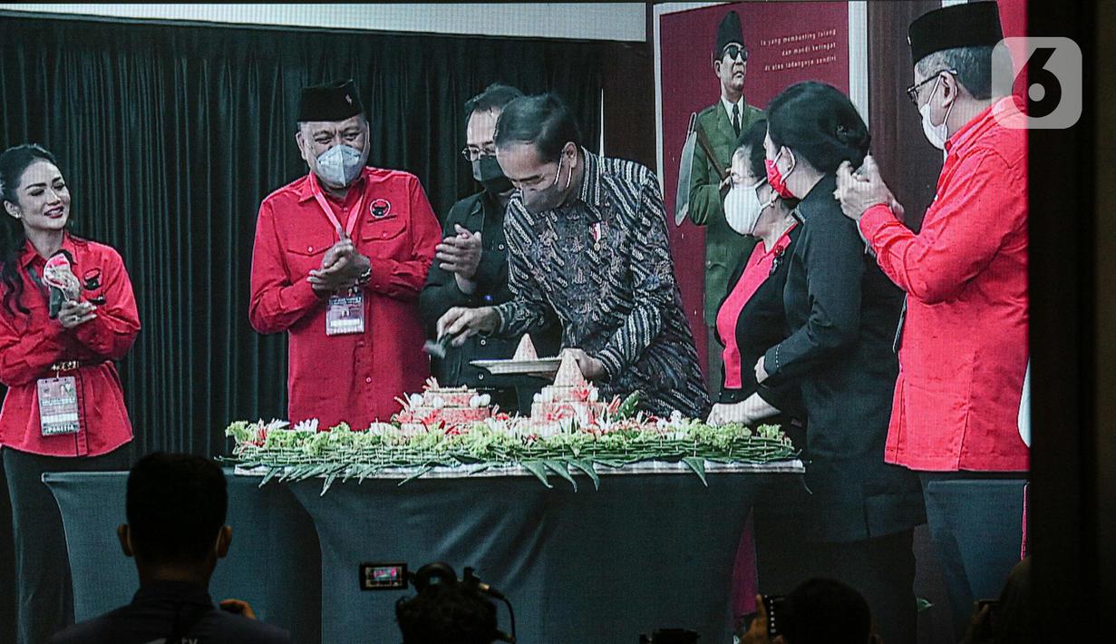 Presiden Joko Widodo atau Jokowi (tengah) memotong tumpeng disaksikan Ketua Umum PDIP Megawati Soekarnoputri (ketiga kanan) saat Rakernas II PDIP di Jakarta, Selasa (21/6/2022). Rakernas PDIP kali ini mengusung tema 'Desa Kuat, Indonesia Maju dan Berdaulat'. (Liputan6.com/Faizal Fanani)