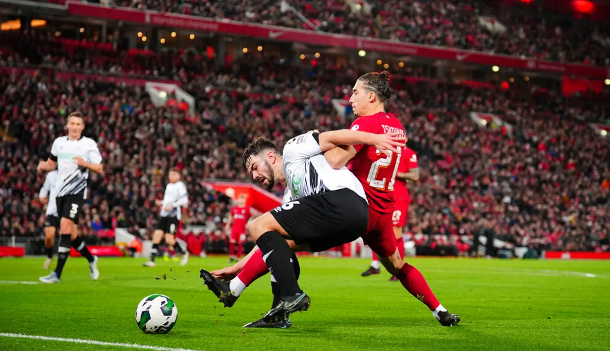 Pemain Liverpool Kostas Tsimikas (kanan) berebut bola melawan pemain Derby County Eiran Cashin pada pertandingan sepak bola Piala Liga Inggris atau Carabao Cup di Stadion Anfield, Liverpool, Inggris, 9 November 2022. Liverpool  menyingkirkan Derby County lewat adu penalti dengan skor 3-2. (AP Photo/Jon Super)