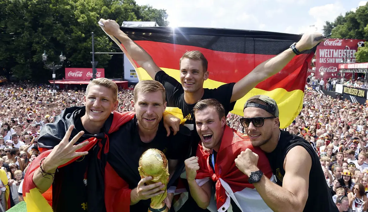 Empat penggawa Timnas Jerman berpose dengan trofi Piala Dunia saat selebrasi kemenangan di Berlin, (15/7/2014). (REUTERS/Alex Grimm/Pool)