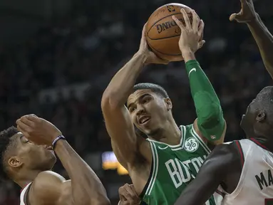 Pemain Boston Celtics, Jayson Tatum (tengah) berusaha melewati adangan dua pemain Bukcs pada laga NBA di basketball game di Milwaukee, (26/10/2017). Boston menang 96-89. (AP/Tom Lynn)