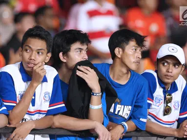 Suporter tim Singo Edan terlihat kecewa saat kekalahan Arema FC dari Persija pada lanjutan Go-Jek Liga 1 Indonesia 2018 bersama Bukalapak di Stadion GBK Jakarta, Sabtu (31/3). Arema FC kalah telak 1-3. (Liputan6.com/Helmi Fithriansyah)