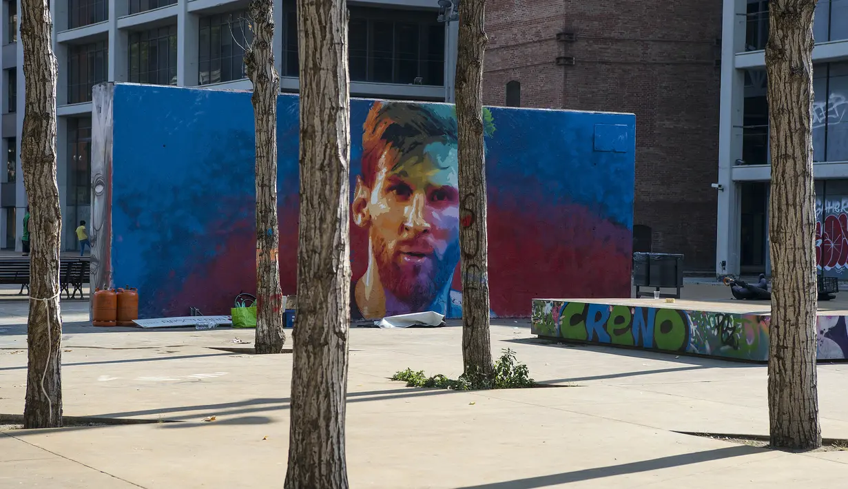 Mural bergambar wajah bintang Barcelona, Lionel Messi, menghiasi sebuah sudut tembok di Barcelona, Catalonia, Sabtu (17/6/2017). (AFP/Josep Lago)