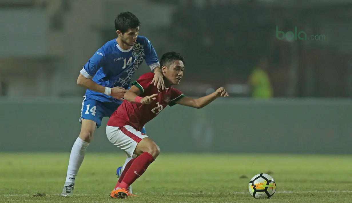 Pemain timnas Indonesia U-23, Septian David Maulana (kanan) berebut bola dengan pemain Uzbekistan pada laga PSSI Anniversary Cup 2018 di Stadion Pakansari, Bogor, (03/5/2018). Indonesia U-23 bermain imbang 0-0. (Bola.com/Nick Hanoatubun)