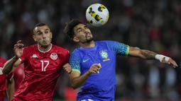 Gelandang Timnas Brasil Lucas Paqueta berduel memperebutkan bola dengan gelandang Tunisia Elles Skhiri dalam laga uji coba internasional di Stadion Parc des Princes, Rabu (28/9/2022) dini hari WIB. Timnas Brasil menang dengan skor telak 5-1 atas Tunisia dalam pertandingan FIFA Matchday. (AP Photo/Christophe Ena)