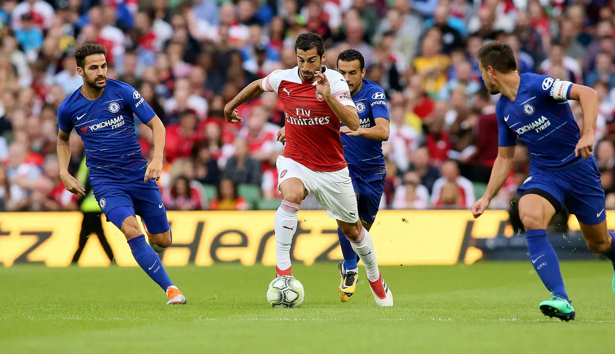 Gelandang Arsenal Henrikh Mkhitaryan menggiring bola dari kejaran tiga pemain Chelsea saat bertanding pada  International Champions Cup (ICC) di Stadion Aviva di Dublin (1/8). Arsenal menang atas Chelsea lewat adu penalti 6-5. (AFP Photo/Paul Faith)