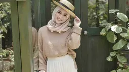 Gaya hijab dengan warna yang earth dan tambahan aksesoris topi jerami, membuat senyuman Melody semakin indah. (Liputan6.com/IG/@melodylaksani92)