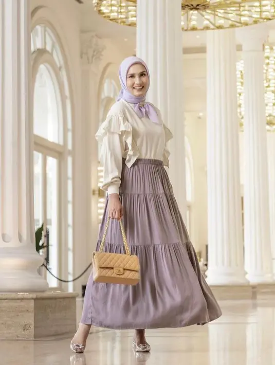 Kombinasi tiered skirt warna ungu yang dipadu puff sleeves top warna putih tulang dan hijab segi empat warna lilac ini membuat penampilan Dwi terlihat manis. (Instagram/dwihandaanda).