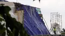 Petugas melihat sisa robohnya bangunan proyek Apartemen Pakubuwono Spring 3 yang ditutupi terpal di Jalan Teuku Cut Nyak Arief, Jakarta, Rabu (27/12). Akibat insiden ini, tiga orang tewas. (Liputan6.com/JohanTallo)