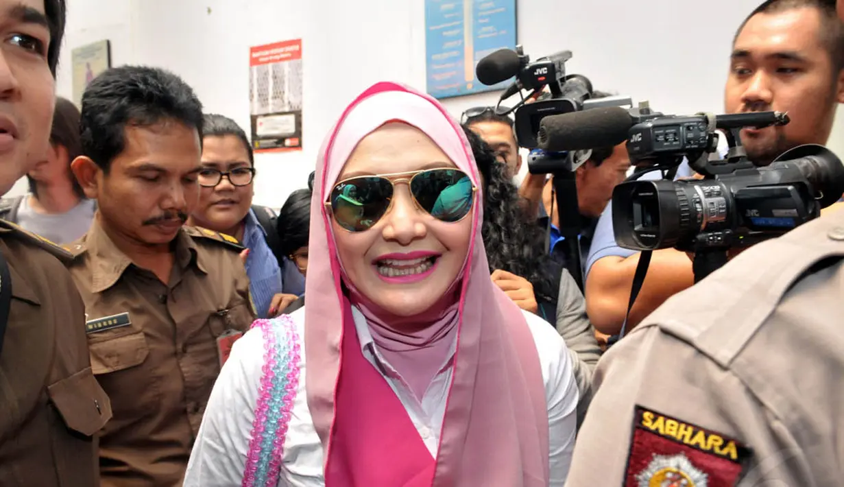 Mengenakan jilbab pink, Eddies Adelia terlihat menebar senyum saat tiba di Pengadilan Negeri Jakarta Selatan, Rabu (12/11/2014). (Liputan6.com/Panji Diksana)