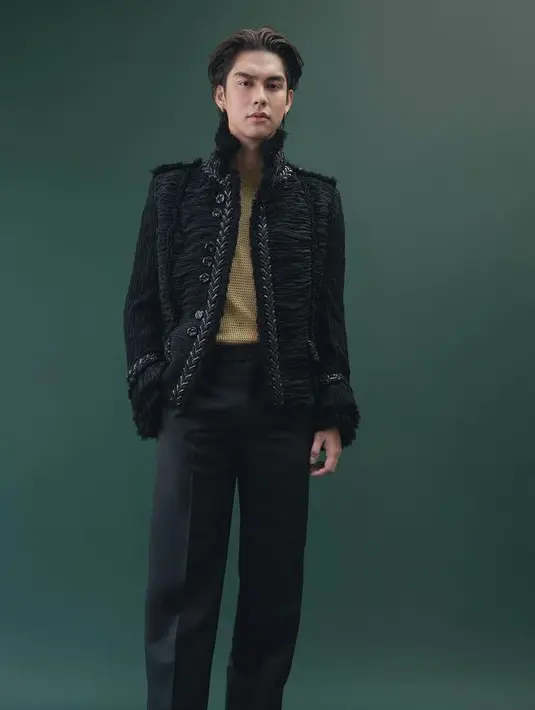Bright Vachirawit, aktor Thailand ini mengenakan setelan hitam dari Burberry. Dari ujung kepala hingga ujung kaki, terlihat di sini dengan jaket georgette lipit hitam dengan sulaman bunga batangan; tank top jaring emas; dan celana tuksedo yang ramping. [@burberry]