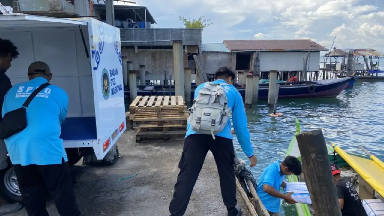 Petugas SPPG yang sedang mengangkut bahan makanan ke dari atas kapal kecil di Pulau Belakangpadang, Batam, Kepulauan Riau.