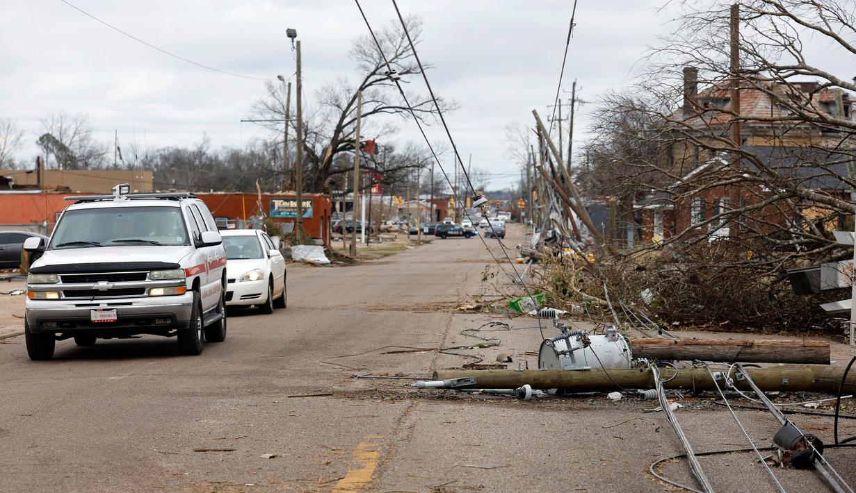 Mobil melewati pepohonan dan kabel listrik yang tumbang setelah tornado di Chestnut Blvd, Selma, Alabama, Amerika Serikat, 13 Januari 2023. Semua kematian akibat tornado yang dilaporkan di Alabama terjadi di Autauga County, yang terletak di antara Kota Montgomery dan Selma. (AP Photo/Stew Milne)