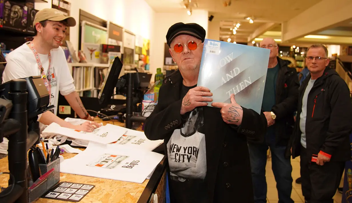 Penggemar berat The Beatles, John Lennon, yang mengganti namanya dari Alan Williams pada April 2022, memegang salinan pertama dari lagu terakhir The Beatles yang baru dirilis "Now and Then" usai acara peluncuran khusus tengah malam di HMV Liverpool, Inggris Jumat (3/11/2023). (Peter Byrne/PA via AP)