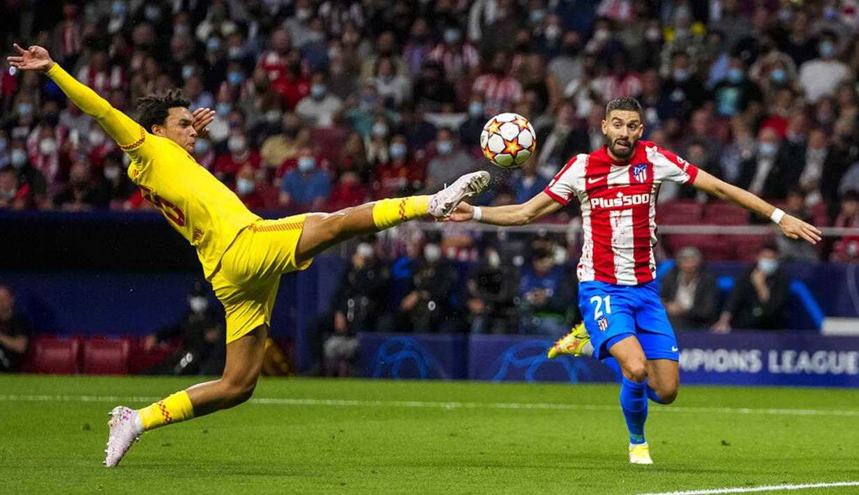 Pemain Liverpool Trent Alexander-Arnold (kiri) berduel memperebutkan bola dengan pemain Atletico Madrid Yannick Carrasco pada pertandingan sepak bola Grup B Liga Champions di Stadion Wanda Metropolitano, Madrid, Spanyol, Selasa (19/10/2021). (AP Photo/Manu Fernandez)