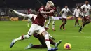 Striker AC Milan, Samu Castillejo, berusaha melewati bek Torino, Ola Aina, pada laga Coppa Italia di Stadion San Siro, Milan, Selasa (28/1). Milan menang 4-2 atas Torino. (AFP/Miguel Medina)