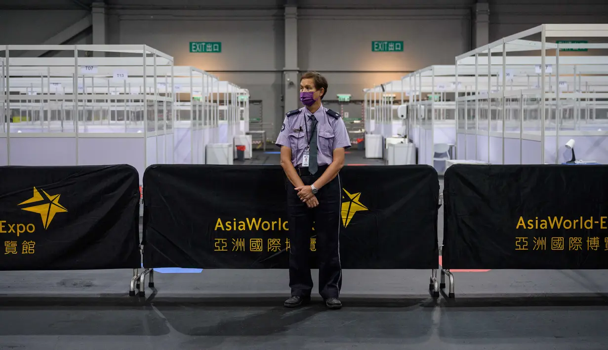 Seorang petugas keamanan berjaga di fasilitas perawatan kesehatan masyarakat di AsiaWorld-Expo di Hong Kong, Selasa (24/11/2020). Otoritas Hong Kong membuka kembali rumah sakit darurat khusus corona tersebut menyusul lonjakan kasus COVID-19 belakangan ini (Anthony WALLACE/AFP)