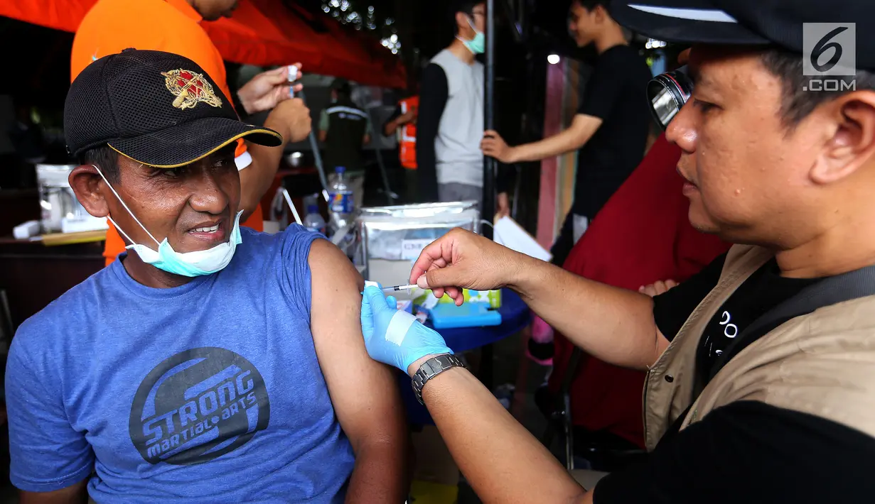 Petugas  mevaksin Td (Tetanus difteri) kepada warga korban gempa di kantor Dinkes Palu, Sulawesi Tengah, Minggu (7/10). Kemenkes dan Bio Farma memberikan 1000 vial vaksin Td untuk relawan dan masyarakat yang terdampak gempa. (Liputan6.com/Fery Pradolo)
