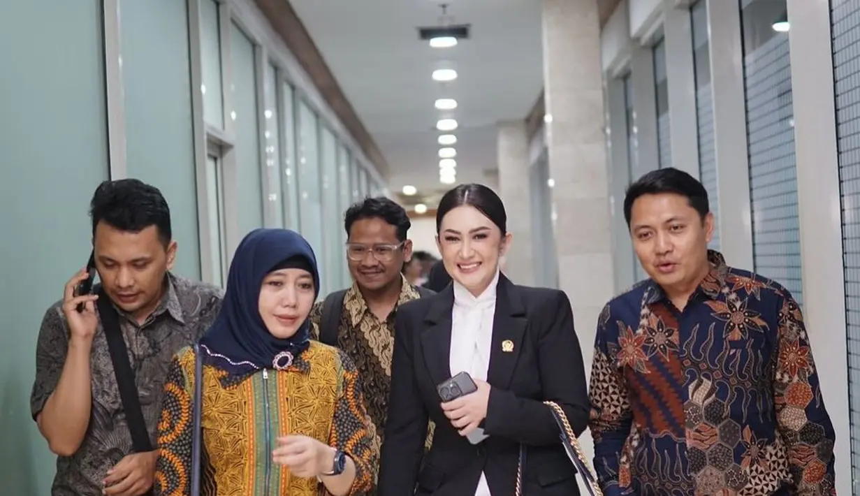 Potret lainnya mengenakan blazer hitam, blus dengan detail ruffle, dan shoulder bag warna senada.  [@nafaurbach].