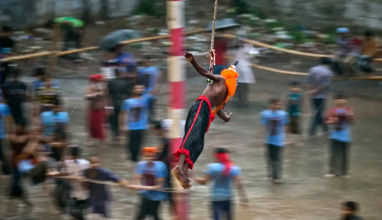 Seorang penganut Hindu berpakaian seperti Dewa tergantung dengan kaitan yang ditusuk di punggungnya saat festival Charak Puja di Dhaka, Bangladesh (14/4). (AP Photo / A.M. Ahad)