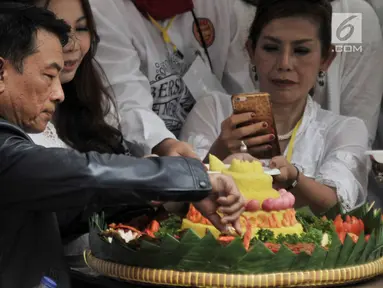 Ketua Harian TKN Moeldoko memotong tumpeng saat syukuran relawan Jokowi-Ma'ruf Amin di Jakarta, Minggu (21/4). Acara syukuran tersebut diisi oleh doa bersama, mengheningkan cipta, dan potong tumpeng. (merdeka.com/Iqbal Nugroho)