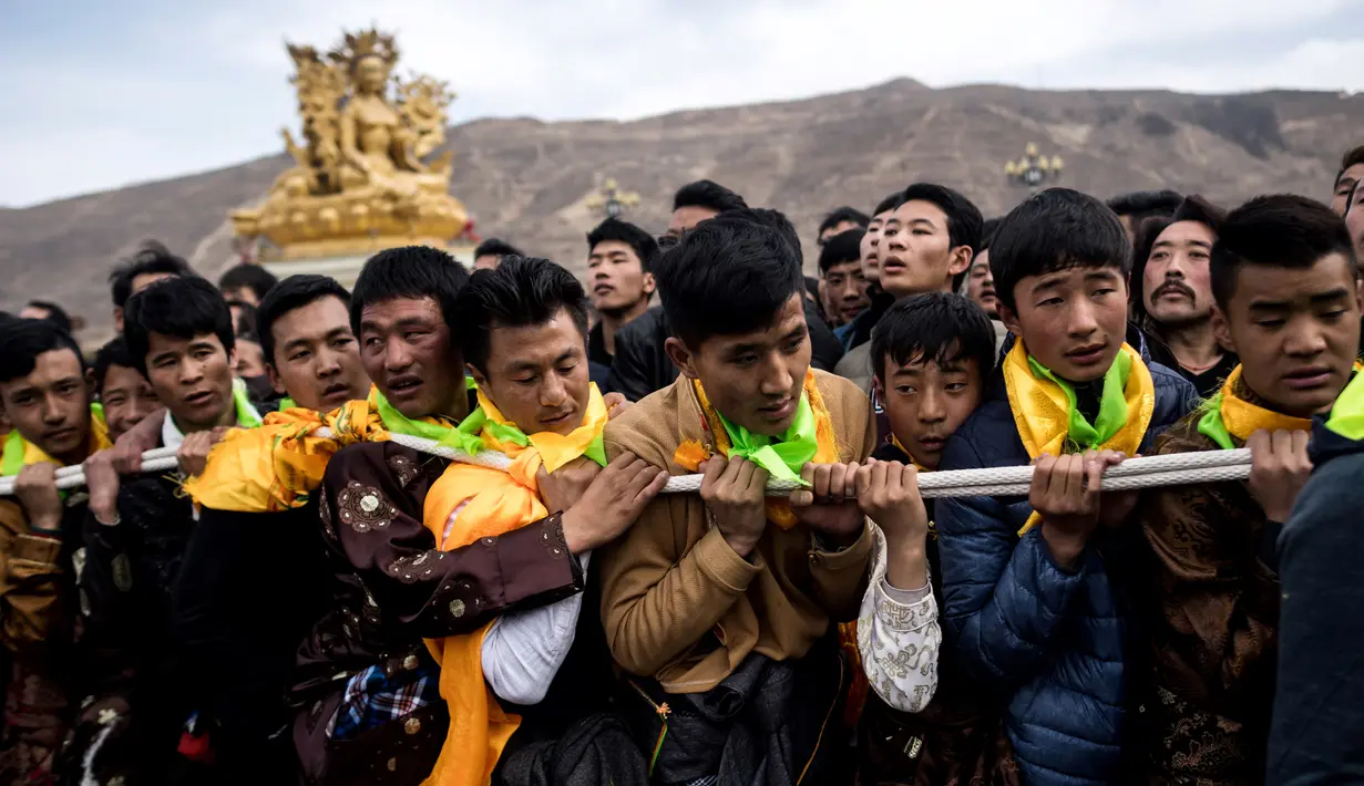 Penganut Budha Tibet menarik thangka raksasa saat upacara Monlam atau yang dikenal Festival Doa Agung Losar di Biara Rongwo, Tibet (1/3). Upacara ini diselenggarakan pada bulan pertama Tahun Baru Tibet. (AFP/Johannes Eisele)
