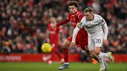 Pemain Liverpool, Curtis Jones (kiri) berebut bola dengan pemain West Ham United,Jarrod Bowen pada laga perempat final Carabao Cup 2023/2024 di Anfield, Liverpool, Inggris, Kamis (21/12/2023) dini hari WIB. (AFP/Oli Scarff)