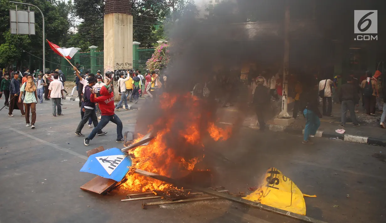Rambu lalu lintas terbakar saat pelajar berdemonstrasi di belakang Gedung DPR, Palmerah, Jakarta, Rabu (25/9/2019). Polda Metro Jaya mengamankan 200 pelajar yang berdemonstrasi. (Liputan6.com/Angga Yuniar)