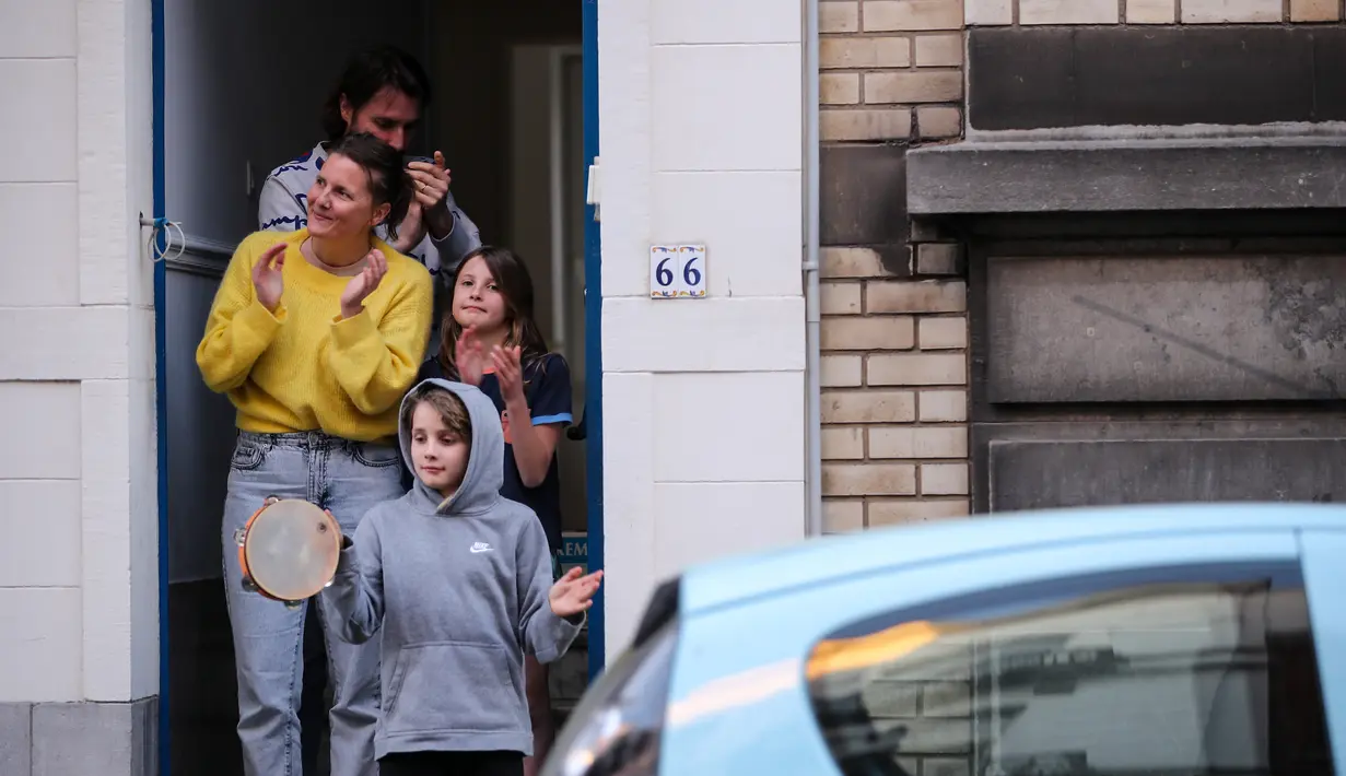 Warga bertepuk tangan dari pintu untuk menunjukkan penghormatan terhadap orang-orang yang bertugas di garis depan melawan pandemi virus corona COVID-19 di Brussel, Belgia,Selasa (14/4/2020). Kasus COVID-19 di Belgia terkonfirmasi sebanyak 31.119 positif dan 4.157 meninggal. (Xinhua/Zhang Cheng)
