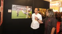 Presiden Joko Widodo atau Jokowi melihat pameran foto 'Membangun Indonesia'  di Jakarta, Selasa (12/11/2019). Pameran foto Membangun Indonesia itu menampilkan sejumlah capaian kinerja pemerintahan Presiden Joko-Widodo dan Wakil Presiden Jusuf Kalla. (Liputan6.com/Angga Yuniar)