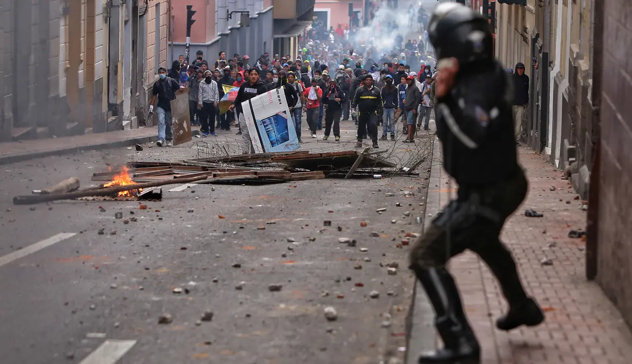 Polisi anti huru hara saat menghadapi demonstran selama bentrokan di Quito (7/10/2019). Para demonstran memprotes terhadap keputusan Presiden Ekuador Lenin Moreno yang mencabut subsidi bahan bakar. (AFP Photo/Cristina Vega)