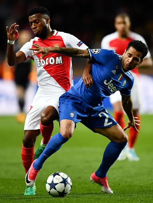 Bek Juventus, Dani Alves (depan) berusaha membawa bola dari kawalan gelandang AS Monaco, Thomas Lemar di leg pertama semifinal Liga Champions di stadion Louis II, Monaco (4/5). Juventus menang atas Monaco dengan skor 2-0. (AFP Photo/Franck Fife)