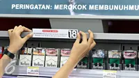 Petugas menempelkan papan peraturan penjualan rokok di gerai Indomaret, Jakarta, Selasa (3/11). Program untuk meningkatkan kesadaran masyarakat akan pelarangan pembelian produk tembakau oleh anak di bawah 18 tahun. (Liputan6.com/Immanuel Antonius)