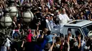 Ini menjadi yang perdana, Paus Leo XIV menaiki kendaraan kepausan "popemobile" jelang misa pelantikan yang akan digelar di Lapangan Santo Petrus Basilika di Vatikan, Minggu, 18 Mei 2025. (Tiziana FABI/AFP)