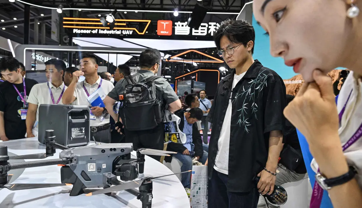 Pengunjung terlihat di stan DJI selama Drone World Congress (DWC) di Shenzhen pada 21 Mei 2026. (HECTOR RETAMAL/AFP)